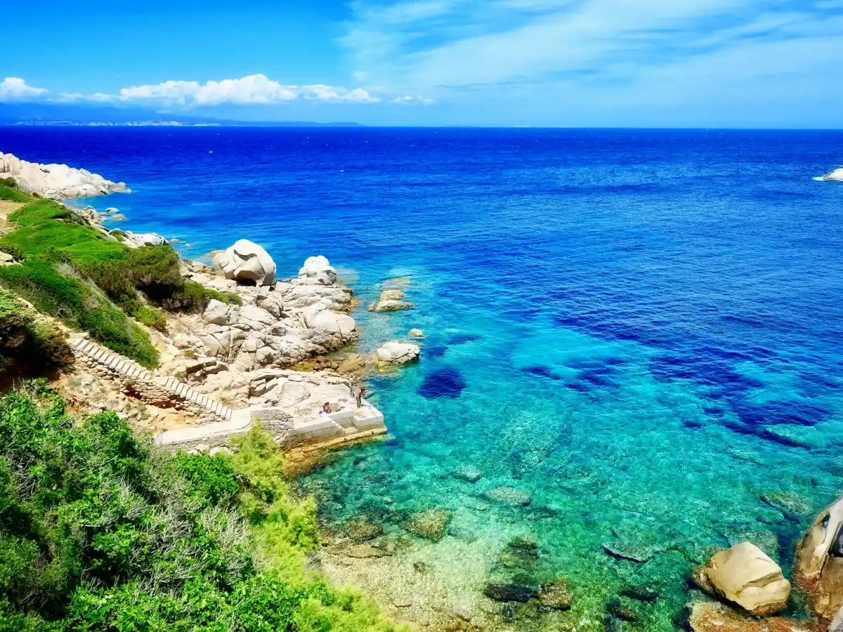 Acquisizioni alberghiere in Italia: baia della Sardegna con costa rocciosa e mare turchese