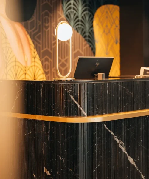 AI agentica in hotel: il bancone della reception di un albergo con schermi per la gestione digitale
