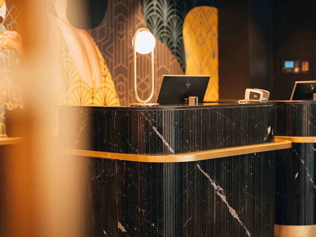 AI agentica in hotel: il bancone della reception di un albergo con schermi per la gestione digitale