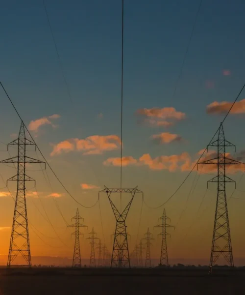 Tralicci dell’alta tensione al tramonto: caro energia hotel e costi delle bollette per gli alberghi italiani