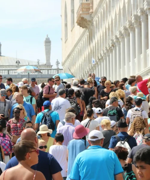 Folla di turisti in una piazza italiana, flussi turistici e overtourism