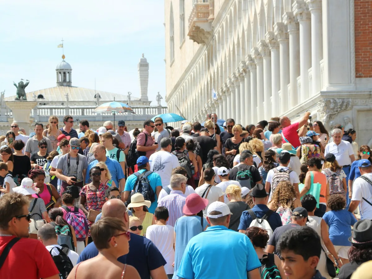 Folla di turisti in una piazza italiana, flussi turistici e overtourism