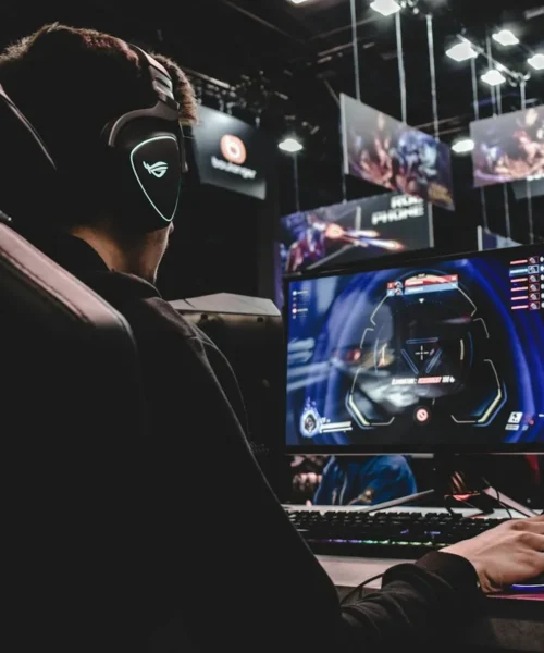 Giocatore in cuffia davanti a una postazione illuminata: gaming in hotel con GAME:NXT by nhow