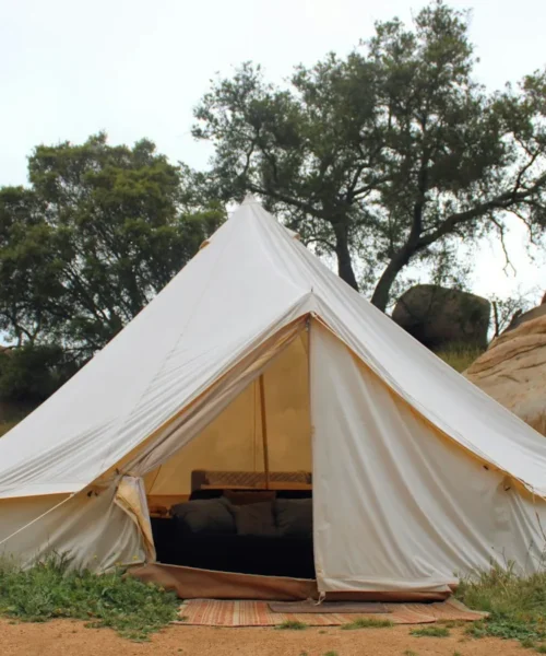 Tenda da glamping bianca su un prato verde: il glamping di fascia alta entra nei network alberghieri