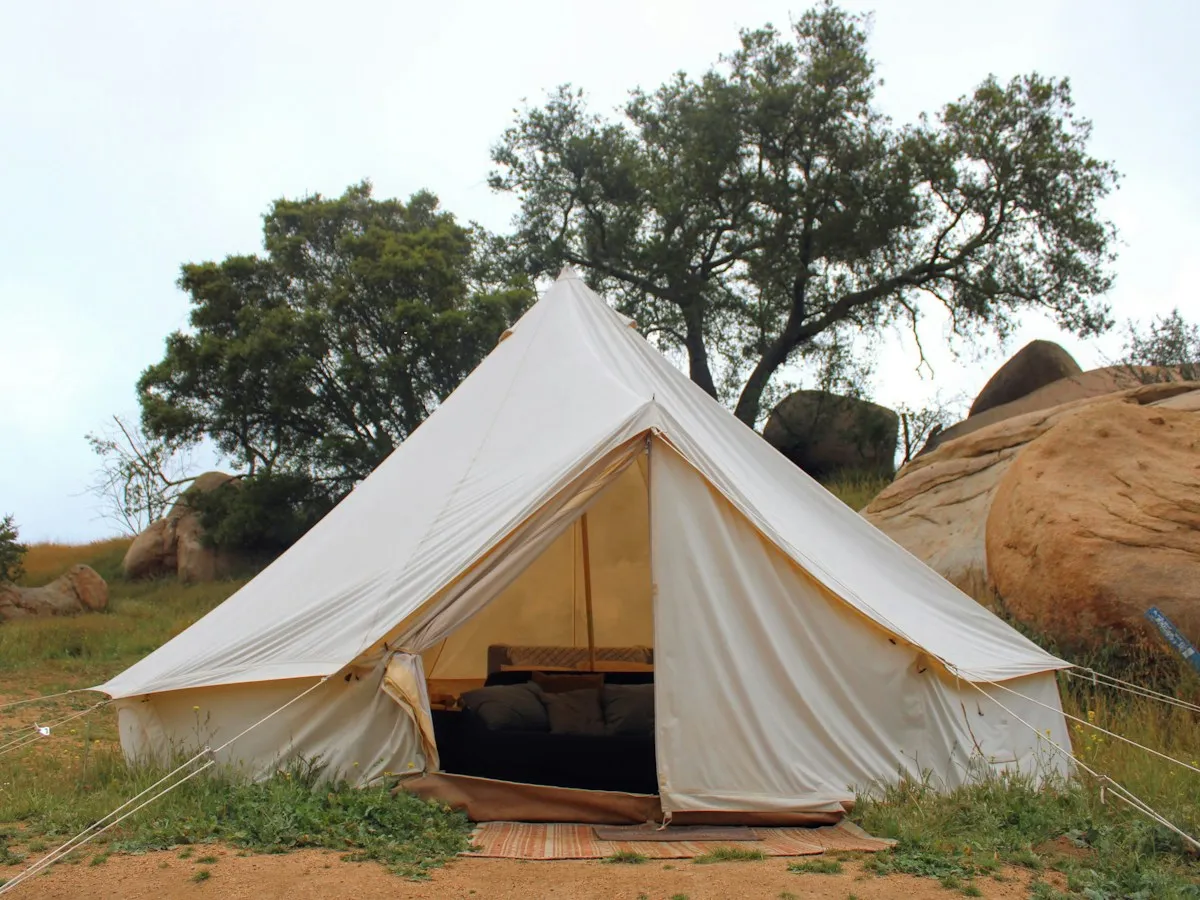 Tenda da glamping bianca su un prato verde: il glamping di fascia alta entra nei network alberghieri