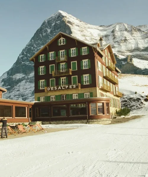Resort di montagna con piste da sci e vette innevate sullo sfondo