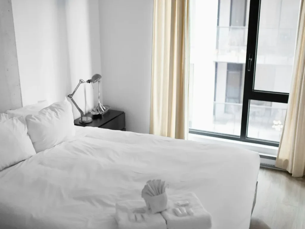 Letto di hotel con biancheria bianca, sleep tourism in camera