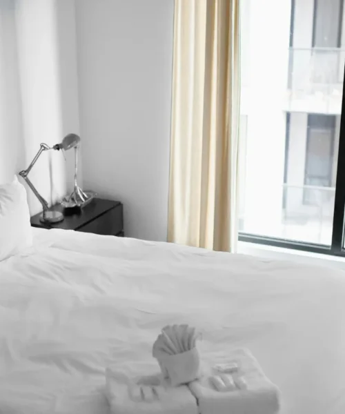 Letto di hotel con biancheria bianca, sleep tourism in camera